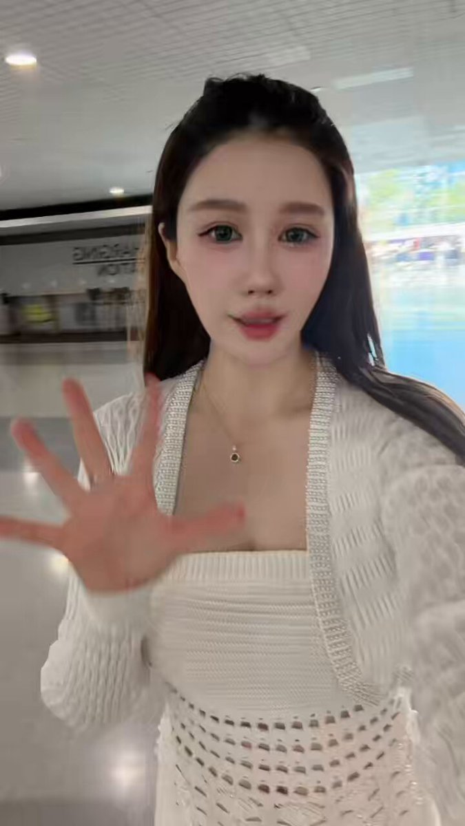 The image features a young woman wearing a white dress with cutouts, standing in front of a glass window or door. She has her hand outstretched towards the camera, creating an engaging and interactive atmosphere for the viewer. The background appears to be a store or mall setting, which could suggest that she is at a shopping center or a similar location. The post includes text that reads "So excited! Let's meet up & connect in ETHConf @ethconf", indicating that this woman might have recently attended an event related to ethical consumerism and wants to share her experience with others through the image.