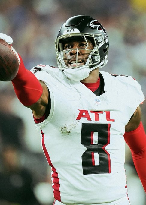 An Atlanta Falcons football player wearing jersey number 8 celebrates while holding up a football in his right hand.