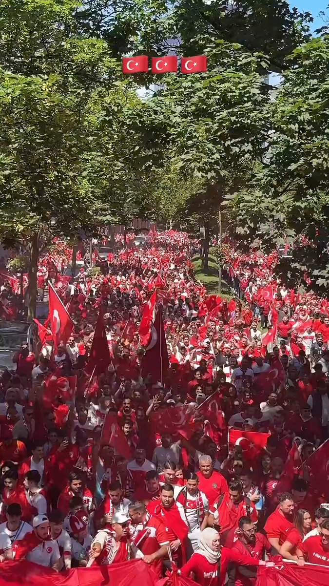 The image shows a large group of people gathered together with red flags, possibly for a political or social event. They are standing close to each other, creating an atmosphere of unity and support. The photo appears to be taken from a high angle, providing a bird's eye view of the crowd and their surroundings. The post that accompanies this image reads "Tomorrow morning, our thing", which suggests that the gathering is likely related to a specific event or cause happening on a particular day in the future.

The presence of red flags indicates some form of protest or demonstration taking place, as people have come together with a common goal or message. The crowd's close proximity and the fact that they are holding up their flags suggest that this is an organized gathering, possibly for political or social reasons.