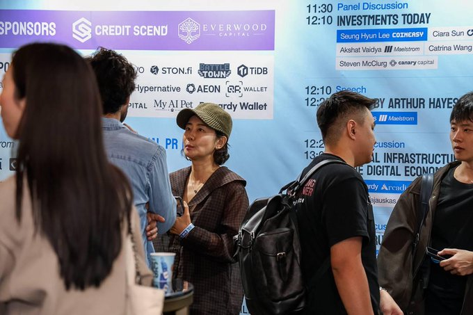 The image shows attendees at Korea Blockchain Week's Hack Season event, standing near a sponsor board featuring "EVERWOOD CAPITAL" and other names like CoinMarketCap, Maelstrom, and Canary Capital. This aligns with the post celebrating Everwood Capital's role as a Title Sponsor, highlighting their commitment to Web3 and AI investments.