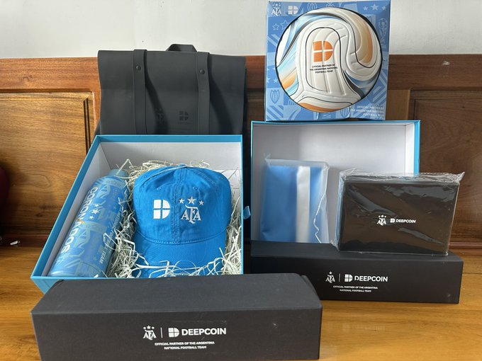 An AFA soccer-themed merchandise gift set from DeepCoin includes a cap, tumbler, tote bag, neck pillow, and pouch in blue and white packaging.
