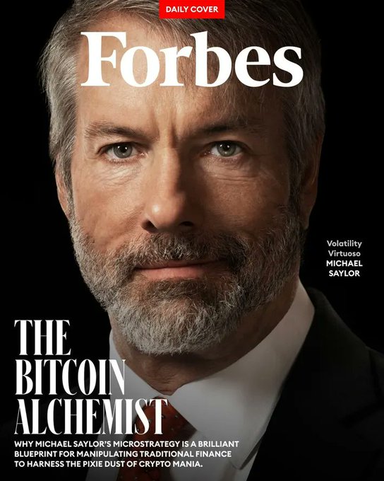 The image features a man wearing a suit, with a beard and mustache. He appears to be posing for an article or magazine cover featuring him as the main subject. The title of the cover reads "The Bitcoin Alchemist," suggesting that this article is about the concept of cryptocurrency and its potential impact on financial strategies. The text in the image indicates that Michael Saylor has made a significant return on his investment, with the stock price now being down 64.42%. This information is likely related to the content of the cover and can be inferred from the surrounding context or additional details provided.
