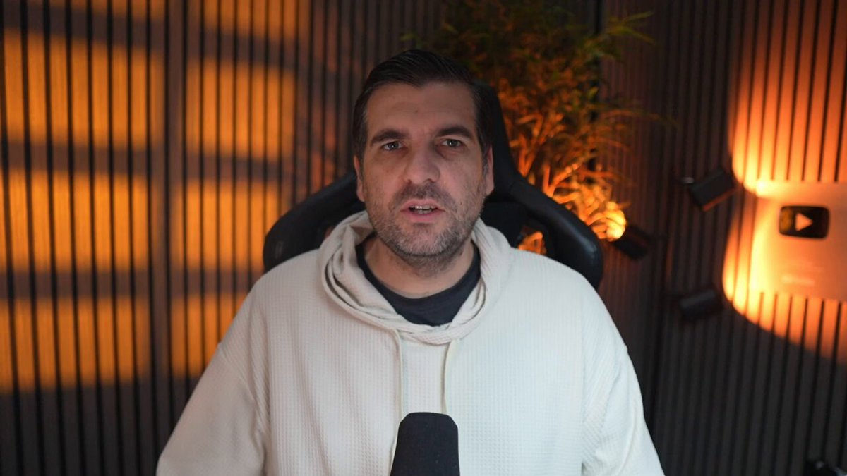 The image shows a man wearing a white hoodie, sitting in front of a microphone with a green plant behind him. The man appears to be talking or giving a speech, possibly at a live event or webinar. The background features a wall with orange lights and blinds that cast shadows on the scene. The post about Charles Hoskinson walking away from a quarter billion dollar empire suggests that there might have been a significant change in his life, such as the closure of a large health clinic. This could be seen as a sign of failure or an indication of the transition from academic theory to real-world application. It is difficult to determine the exact context and implications of this event without more information about it.