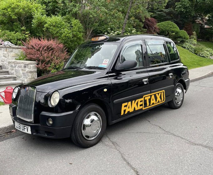 A glossy black London-style taxi parked on a driveway displays bold yellow lettering reading "FAKETAXI" along its side, with the front plate showing "L51 UFV" and a matching "TAXI" rooftop sign. The image humorously illustrates the tweet's play on words—arriving in Singapore for Token2049 and claiming the cab as personal transport.