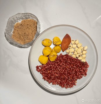A bowl containing various ingredients including red beans, yellow chestnuts, lotus seeds, and a date, alongside a small bowl of brown sugar, likely ingredients for a traditional dessert or porridge.