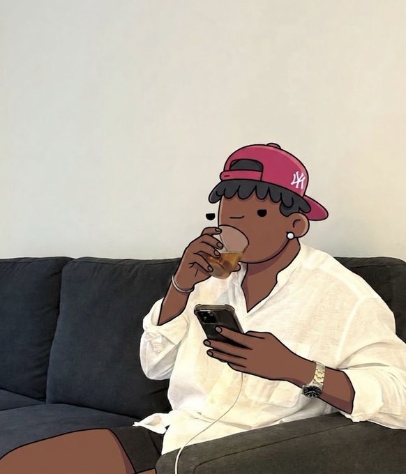 A person in a white shirt and pink cap drinks from a glass while looking at a smartphone, with their face obscured by a cartoon-style sticker featuring a pink cap with the number '44'.