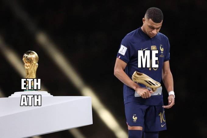 A dejected Kylian Mbappé in his #10 France jersey holds a golden boot labeled "ME," while the FIFA World Cup trophy on a pedestal is labeled "ETH ATH" — symbolizing Ethereum's prior inability to reach a new all-time high, much like Mbappé's missed chance at the World Cup trophy.