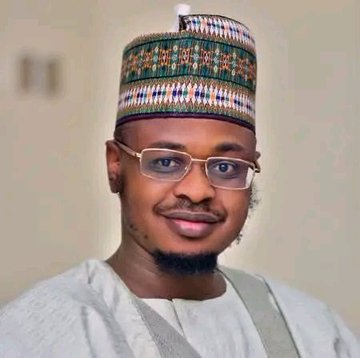A young man with glasses and a neatly trimmed beard wears a traditional embroidered cap and white attire, posing for a portrait. The image accompanies a post highlighting that professionals with skills similar to Professor Isa Ali Pantami earn annual salaries of $300,000–$450,000 at top tech and crypto companies like Google, Microsoft, Amazon, and Binance.