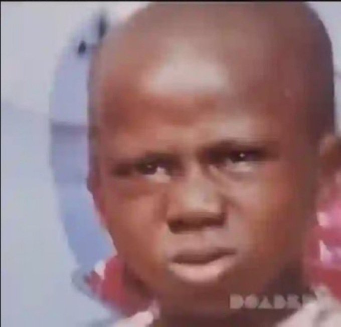 A low-resolution, close-up image of a baby's face with a confused or skeptical expression, with partial 'DOA' text visible in the corner.