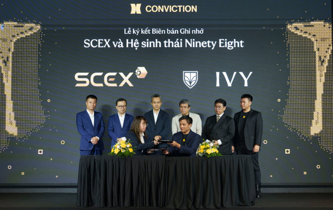 A signing ceremony at Conviction featuring executives from SCEX and IVY, with a Vietnamese caption "Lễ ký kết Biên bản Ghi nhớ SCEX và Hệ sinh thái Ninety Eight" (MOU signing between SCEX and the Ninety Eight ecosystem).
