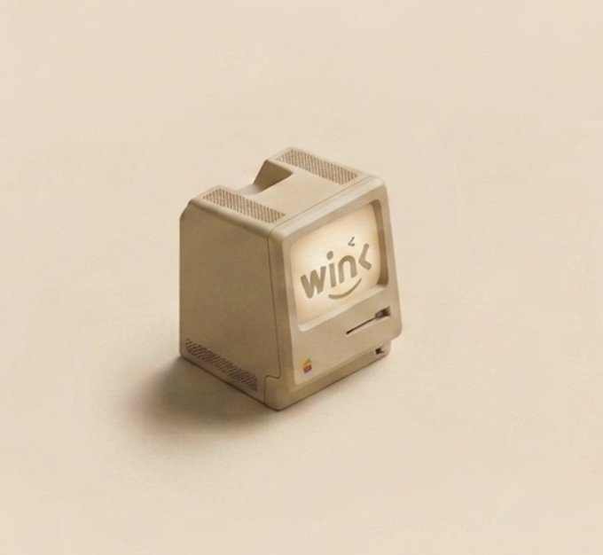 A 3D rendering of a miniature retro Macintosh computer displaying the word 'wink' with a smiley face on its screen, set against a plain beige background.