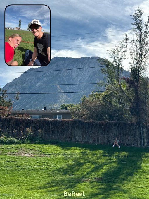 A 'BeReal.' screenshot showing a main image of a backyard with a mountain backdrop and an inset photo of a young man and woman posing outdoors.