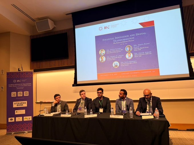 A panel discussion at Oakland University featuring speakers at a table, with a screen behind them titled 'Financial Innovation and Digital Transformation: The Future of Islamic Finance,' hosted by Stearns Bank.