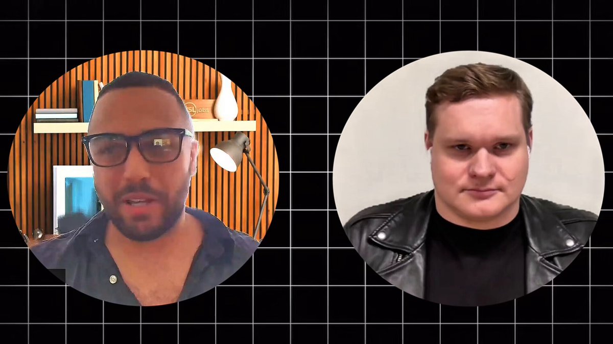 The image features two men wearing glasses, with one man dressed more formally in a leather jacket while the other wears a t-shirt. They are both looking at the camera, appearing engaged in an interview or discussion. The background of the image is black and white, which contrasts with the colorful elements on the left side of the frame.
