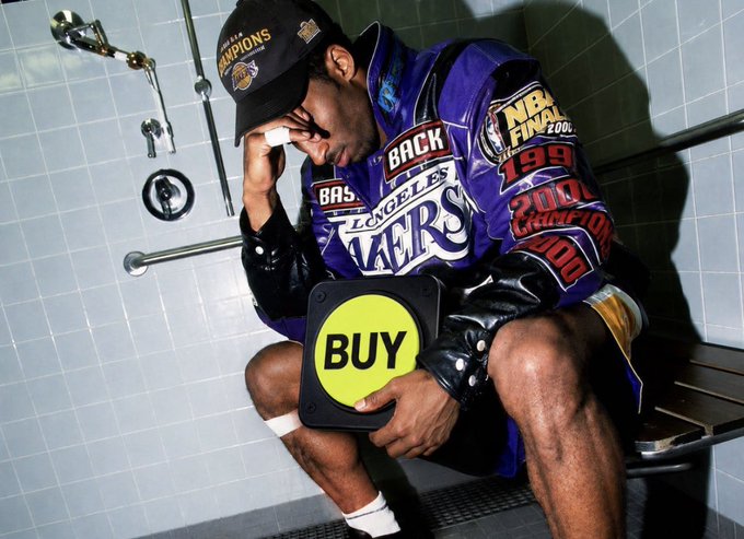Kobe Bryant, wearing a Lakers championship jacket and 'BACK TO BACK CHAMPIONS' hat, sits on a bench wiping his face with a bright yellow 'BUY' sign superimposed over his lap.