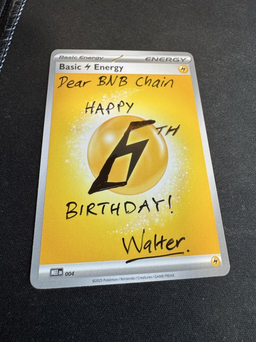 A Pokémon trading card, 'Basic Lightning Energy' (SWSH 004/202), with handwritten text reading 'Dear BNB Chain, Happy 6th Birthday! Walter.'