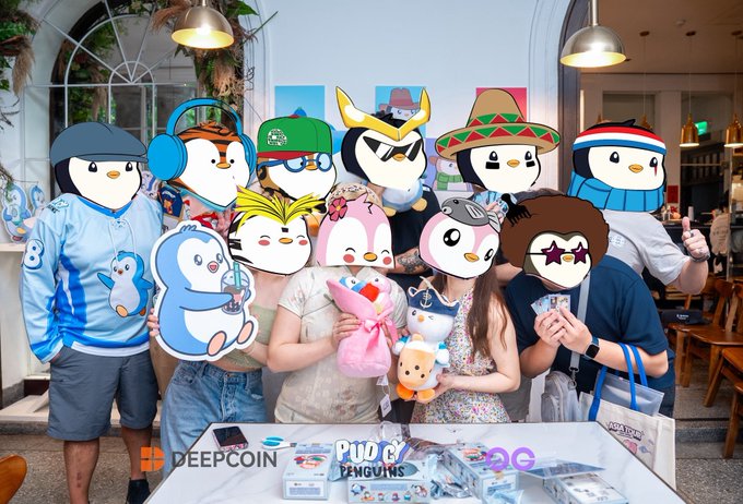 A group photo shows people posing with cardboard cutouts of various cartoon penguin characters, with 'Deepcoin', 'Pudgy Penguins', and '2G' logos visible on the merchandise and signage on the table.