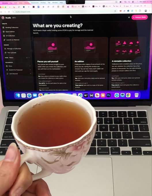 A first-person photo of a hand holding a floral teacup filled with tea in front of a laptop; the screen displays a webpage asking 'What are you creating?' with options like 'Pieces you sell yourself' and 'An edition'.