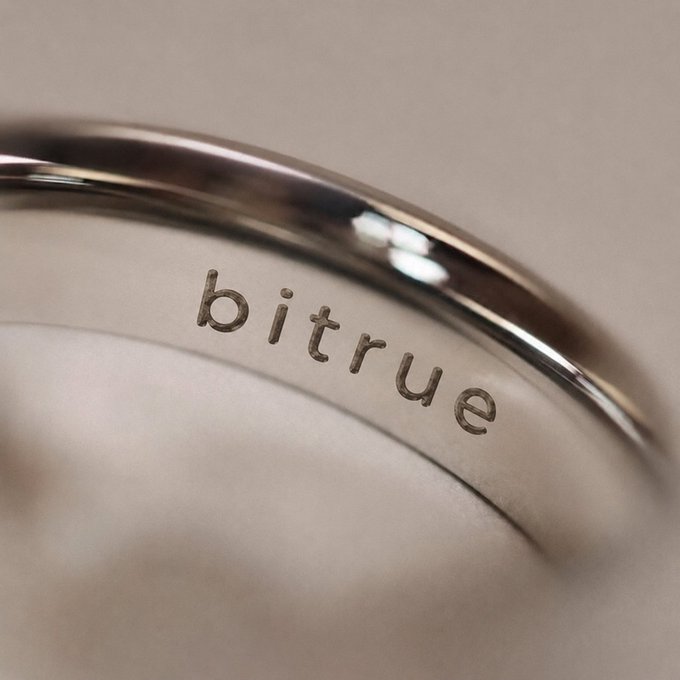 A close-up of a metallic ring engraved with the word "bitrue," symbolizing appreciation and partnership in the accompanying message of gratitude.
