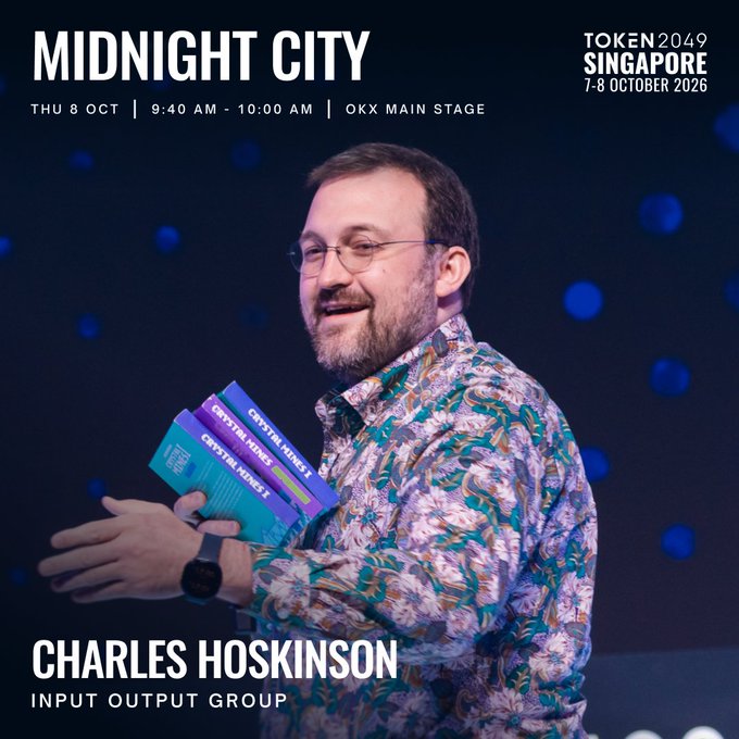 A promotional image for TOKEN2049 Singapore 2026 (7-8 October) features Charles Hoskinson of Input Output Group smiling on stage while holding two copies of "Crypto in Madness 2" books, advertising his "Midnight City" talk on Thu 8 Oct from 9:40 AM - 10:00 AM on the OKX Main Stage.