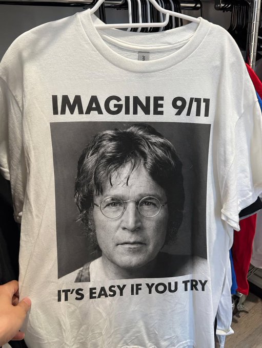 A white t-shirt on a hanger featuring a portrait of John Lennon and the text 'IMAGINE 9/11' and 'IT'S EASY IF YOU TRY.'