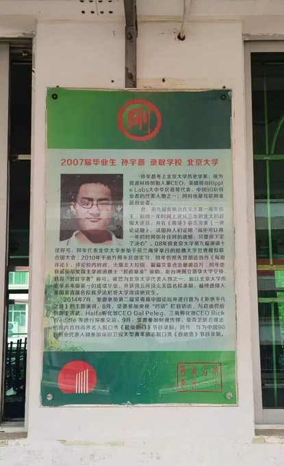 A green poster outside a building celebrates a 2007 graduate, Sun Xuanxu (孙宇晨), who was admitted to Peking University (北京大学), featuring his photo and a biography of his achievements.
