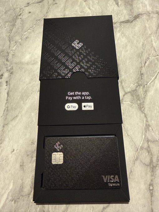 A sleek black ether.fi Visa Signature metal card is displayed in its black presentation box with embossed patterns, featuring Google Pay and Apple Pay logos with the text "Get the app. Pay with a tap." The card's premium black design matches the post's comment about the card arriving quickly and looking stylish.