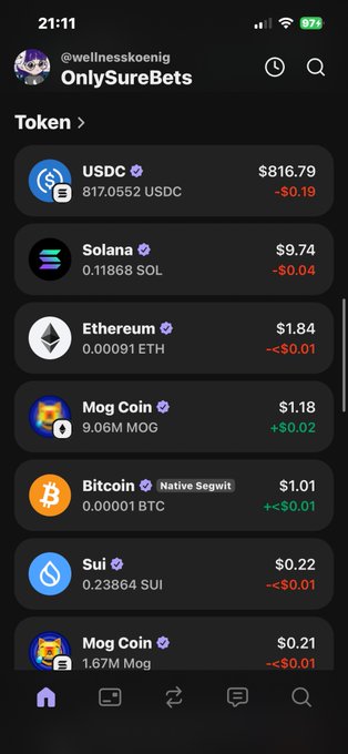 A screenshot of a cellphone displaying an app called "OnlySUREBETS", which is used for cryptocurrency trading, specifically Bitcoin. The phone's screen is dark gray with various Bitcoin symbols along with price and amount details visible. There are no other objects or texts on the image, so it focuses solely on the Bitcoin-related information within the app.