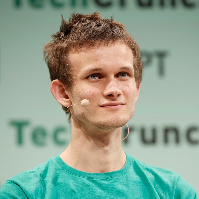Vitalik Buterin, Ethereum co-founder, speaks at TechCrunch Disrupt wearing a headset microphone and a green t-shirt, with the "TechCrunch" logo visible on the backdrop behind him.