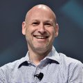 A smiling bald man in a striped collared shirt speaks on stage, likely the SharpLink CFO referenced in the post discussing Ethereum's 875,000 ETH treasury holdings and its advantages over Bitcoin's static holding model.