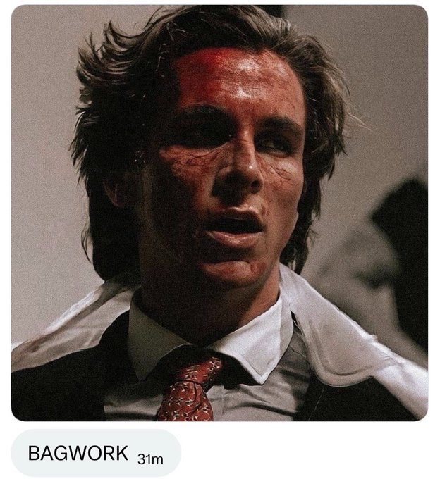 This image shows a close-up of a man's face with blood stains, looking disheveled in a suit and tie, accompanied by the text "BAGWORK". This scene likely symbolizes the intense and potentially "bloody" nature of crypto trading, as hinted at by the post about $CASHCAT's journey to $1B.