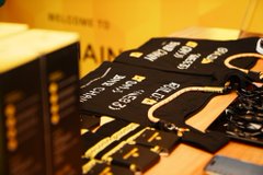 Photograph of stacks of black and gold Bitcoin-themed physical coins or bars on display.