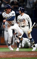 Two Tampa Bay Rays baseball players celebrating on the field, wearing white uniforms with 'RAYS' across the chest.