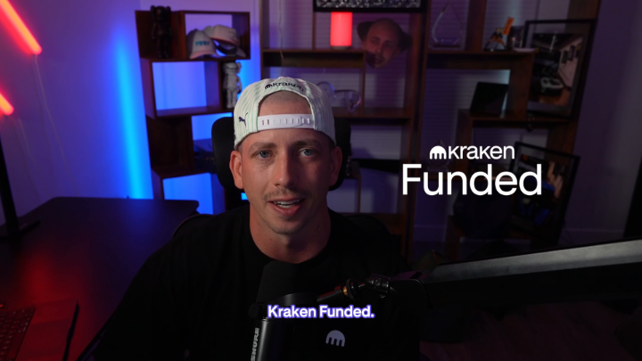 A man wearing a white "Kraken" branded cap sits in a neon-lit streaming setup with "Kraken Funded" displayed on screen, introducing the Kraken funded trader challenge.