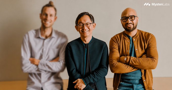 A photo of three smiling men posing together, with the 'MystenLabs' logo in the top right corner.
