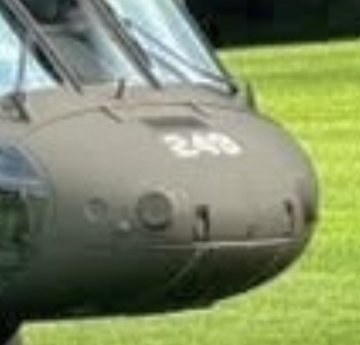 The image shows a close-up of an olive-drab helicopter nose featuring the number "243" stenciled in white on its front. This matches the accompanying post, which references the visible "243" marking as a potential identifier on the helicopter that could provide clues about an upcoming operation or drop.