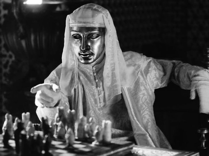 A masked figure in flowing robes sits at a chessboard, extending a finger to move a piece, mirroring the post's advice to play strategic, deliberate moves in the stock market rather than impulsively chasing every "hot sector."