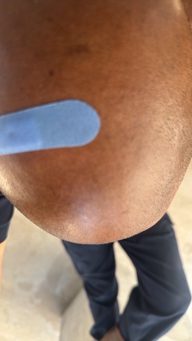 A close-up photograph showing a person's chin and torso as they hold a blue popsicle.