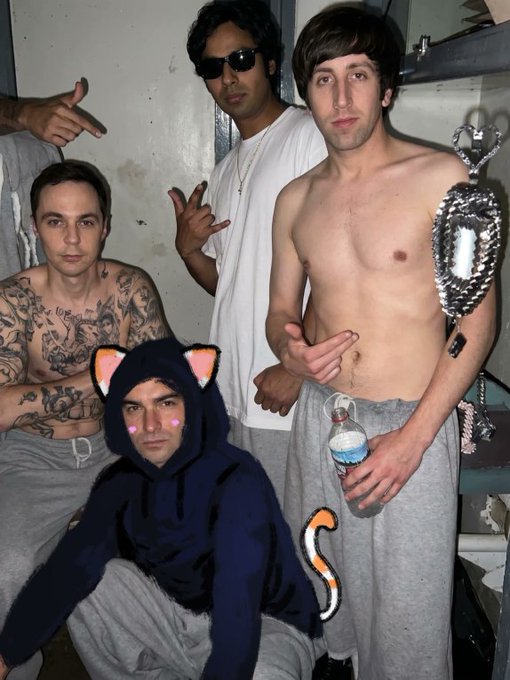 A group of four casually dressed young men pose together, with playful cat ear and tail filters digitally added over one member sitting in the foreground, while one holds a water bottle and a large silver pendant hangs nearby, capturing a candid "before the launch" team moment ahead of TheHoodNFT mint.