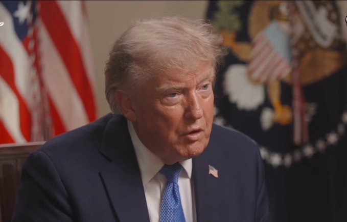 President Trump speaks about the importance of cryptocurrency and the U.S. not losing to China in AI and crypto. The image shows him speaking in front of American flags.