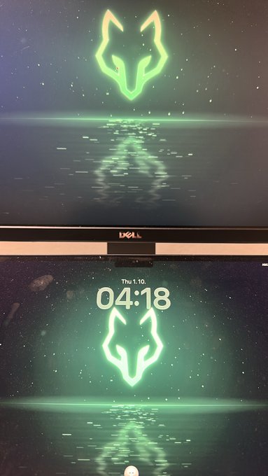 A Dell monitor displays a screensaver of a glowing green wolf-like symbol reflecting on water, with the date "Thu 1.10" and time "04:18" shown below.
