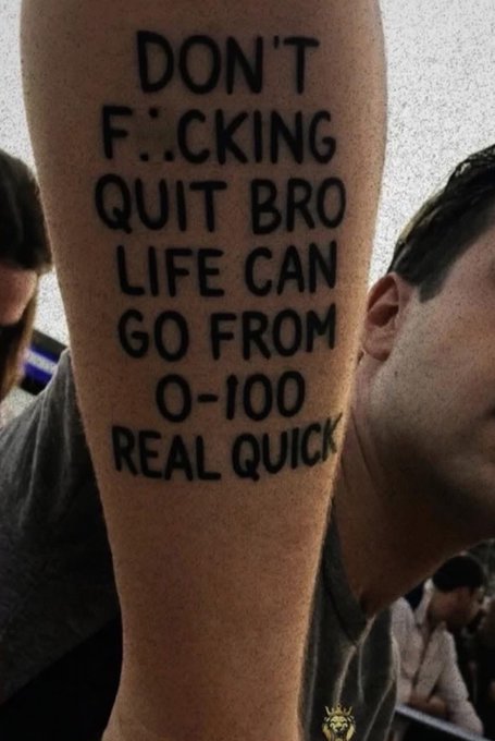 A person's forearm with text written on it in marker that reads 'DON'T F**CKING QUIT BRO LIFE CAN GO FROM 0-100 REAL QUICK'.