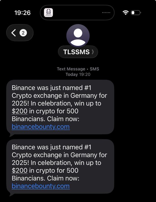 A smartphone screenshot of text messages from TLSSMS containing spam messages reading: 'Binance was just named #1 Crypto exchange in Germany for 2025! In celebration, win up to $200 in crypto for 500 Binancians. Claim now: binancebounty.com', sent twice.