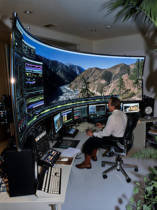 A man sits at an elaborate multi-monitor workstation featuring a massive curved display showing a mountain landscape, with additional trading screens and audio mixing equipment below.

The irony is striking: the post claims "managing my $193 portfolio," yet the setup suggests a high-end professional trading or production studio worth thousands of dollars—a comically disproportionate display of wealth and infrastructure for such a modest amount.