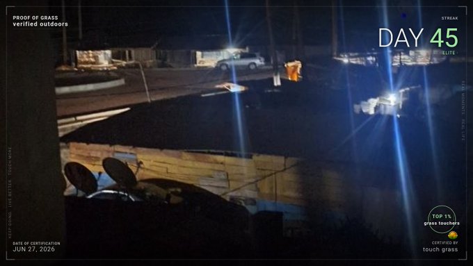 A nighttime image showing a dimly lit outdoor area with satellite dishes visible, overlaid with certification text reading "PROOF OF GRASS verified outdoors," "DAY 45," "STREAK ELITE," and "TOP 1% grass touchers CERTIFIED BY touch grass" dated JUN 27, 2026. The certification graphics directly correspond to the poster's 45-day streak proof, verifying that despite being sick, they forced themselves outside at night to complete their daily outdoor check-in.