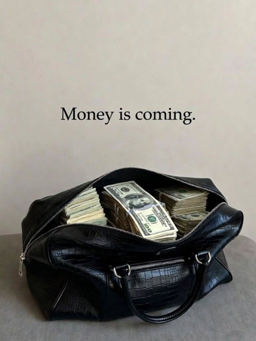 A black textured handbag filled with stacks of U.S. hundred-dollar bills, with the text 'Money is coming.' displayed on a light wall above it.