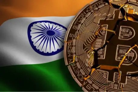 A physical Bitcoin token placed over the Indian flag, symbolizing cryptocurrency adoption in India.
