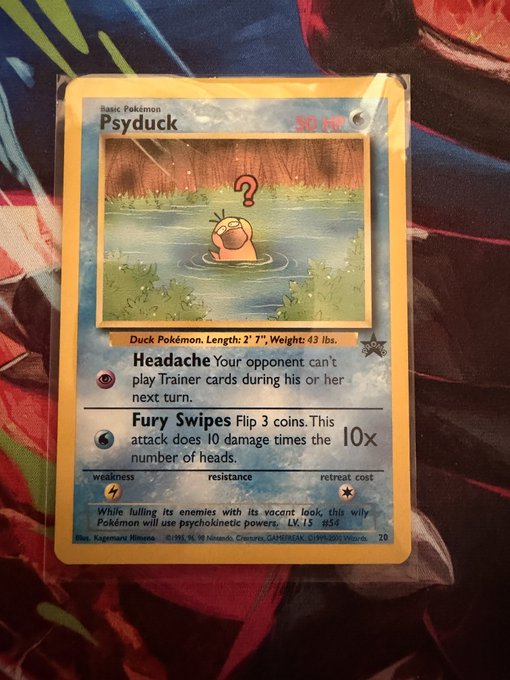 A holographic Psyduck Pokémon trading card from the Neo Genesis set (number 20) sits in a protective sleeve, featuring its 50 HP "Headache" and "Fury Swipes" attacks—supporting the caption's claim that it looks like a rare and valuable collectible.