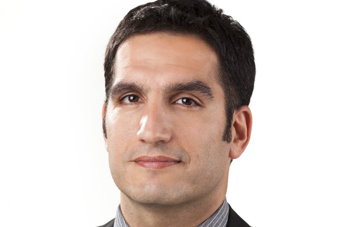 The image features a man wearing a suit with a tie, standing against a white background. He has dark hair and a serious expression as he looks directly at the camera. The caption below the image reads "Enlivex Ltd. (ENLV) announced that its RAIN token has been listed on the HTX cryptocurrency exchange as of April  20, 2026". This information suggests that the man might be involved in the cryptocurrency market or is interested in investing in Enlivex's digital asset.