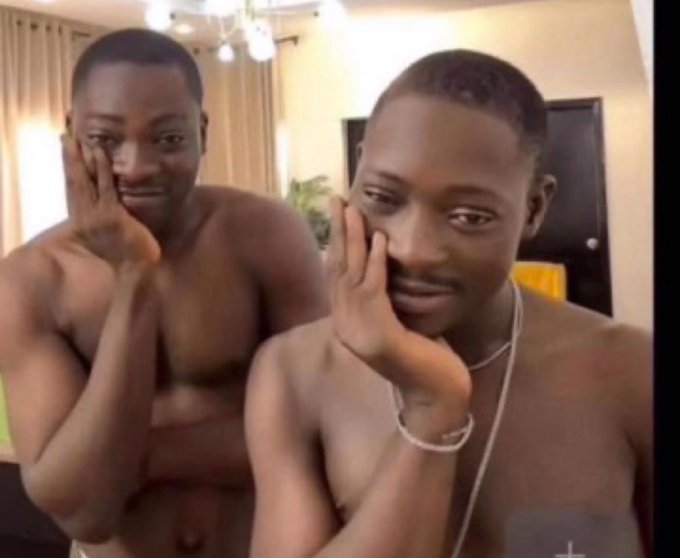 Two shirtless men are making the same hand-to-face gesture, posing together in what appears to be a living room with curtains and a TV in the background. The image humorously illustrates the post's question about finding community, showing the men posing suggestively together as if to demonstrate one of the questionable things members might do in exclusive online communities.
